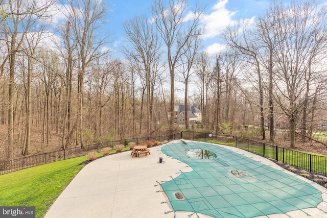 view of swimming pool featuring a patio area and a yard