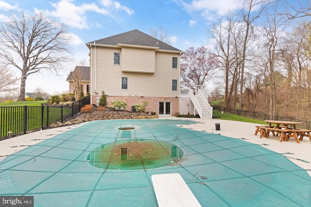 view of pool with a patio area and a diving board