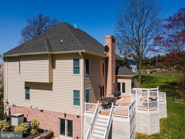 rear view of property featuring a lawn and a wooden deck