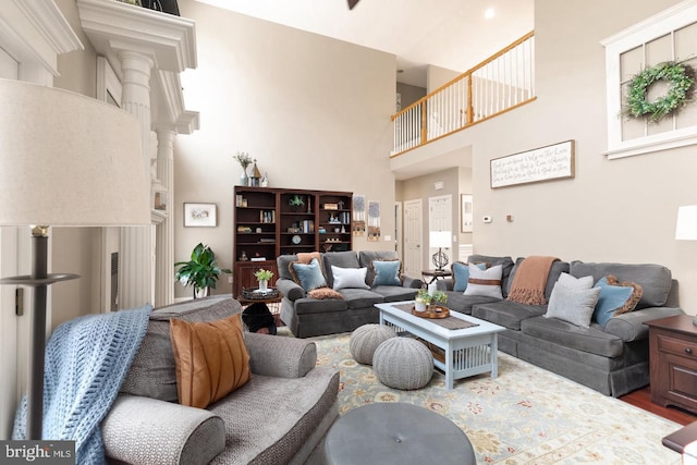 living room featuring wood-type flooring and a high ceiling