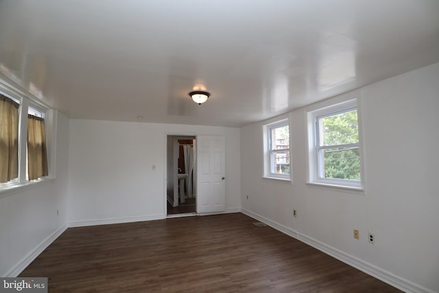 unfurnished room featuring dark wood-style flooring and baseboards