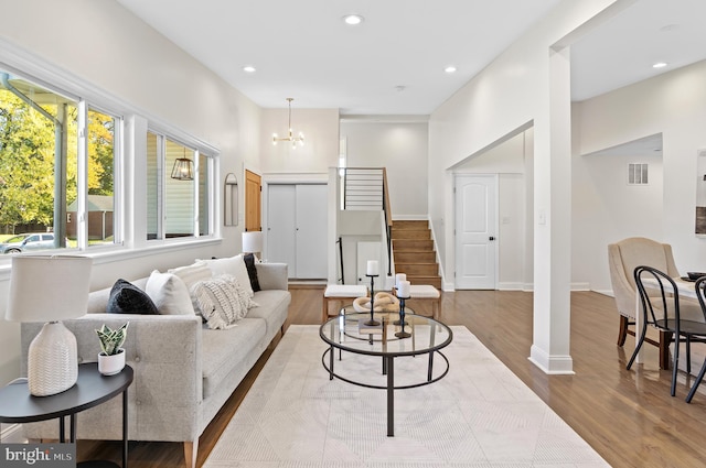 living room with light hardwood / wood-style floors and a notable chandelier