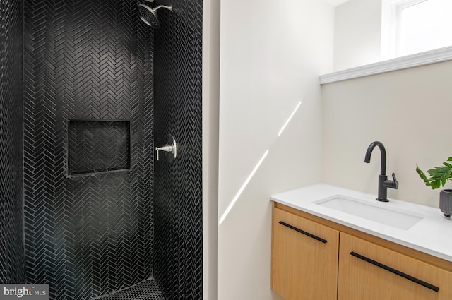 bathroom with vanity and a tile shower