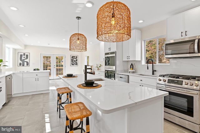 kitchen featuring pendant lighting, a center island, stainless steel appliances, and plenty of natural light