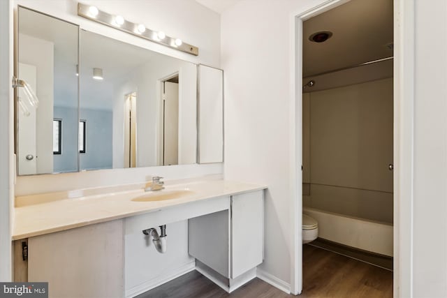 full bathroom with hardwood / wood-style flooring, shower / bathing tub combination, toilet, and sink