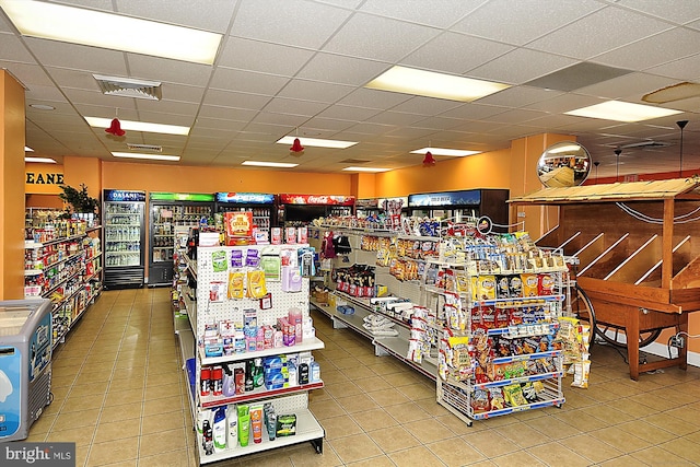 miscellaneous room featuring tile patterned floors and a drop ceiling