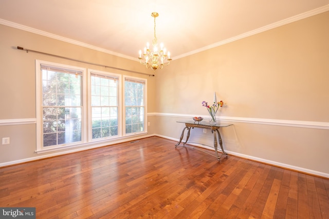 unfurnished room with ornamental molding, a notable chandelier, and wood-type flooring