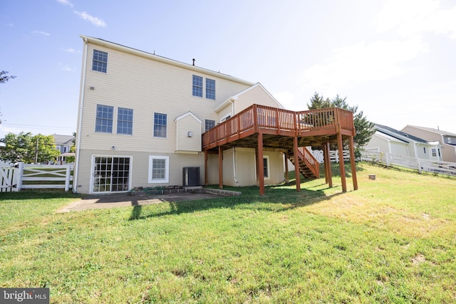 rear view of house with a yard, a wooden deck, and a patio area