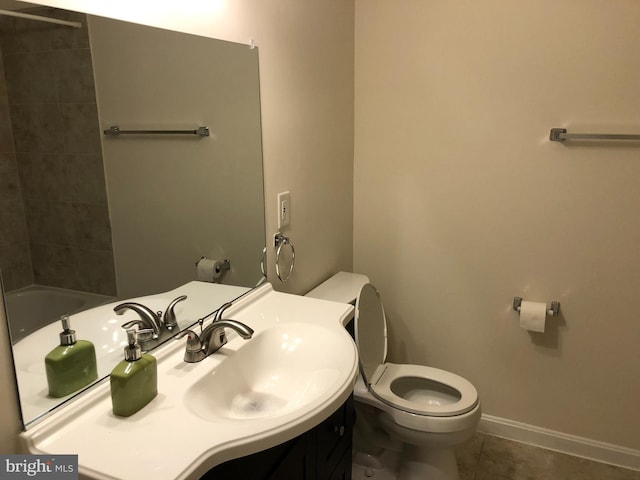 bathroom with tile patterned floors, a tub to relax in, vanity, and toilet