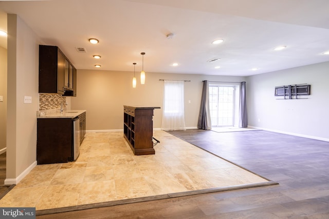 kitchen featuring dark brown cabinets, light wood-type flooring, backsplash, and sink