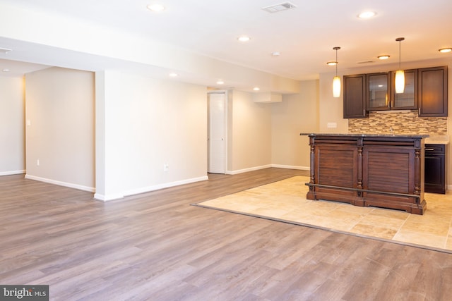 kitchen featuring decorative backsplash, pendant lighting, and light hardwood / wood-style flooring