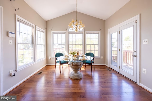 dining room featuring dark wood-type flooring, an inviting chandelier, and lofted ceiling