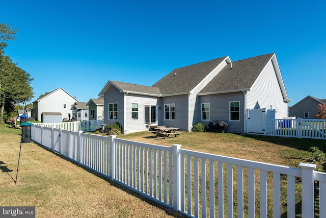 rear view of property with a yard and a garage