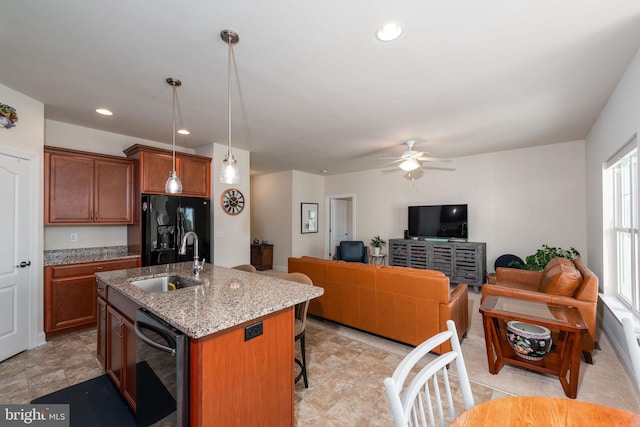 kitchen with ceiling fan, a kitchen island with sink, dishwasher, sink, and decorative light fixtures