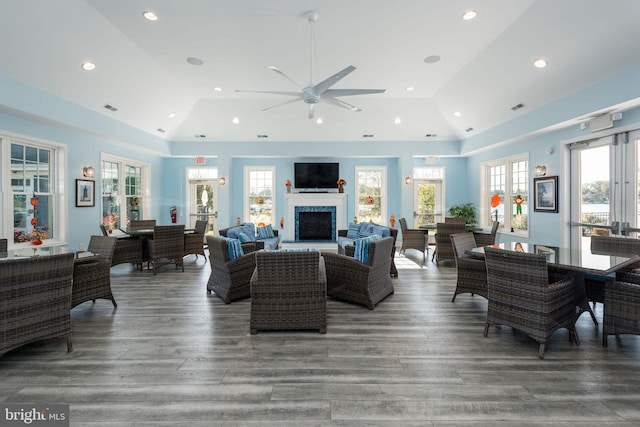 living room featuring wood-type flooring, high vaulted ceiling, and ceiling fan