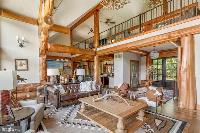 living room with a high ceiling, ceiling fan, french doors, and wood-type flooring