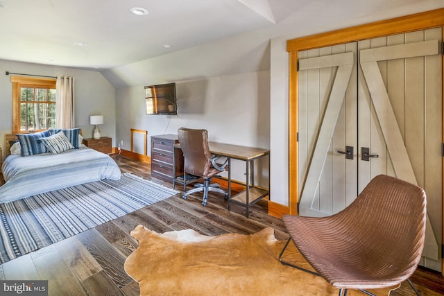 bedroom with vaulted ceiling and dark hardwood / wood-style flooring