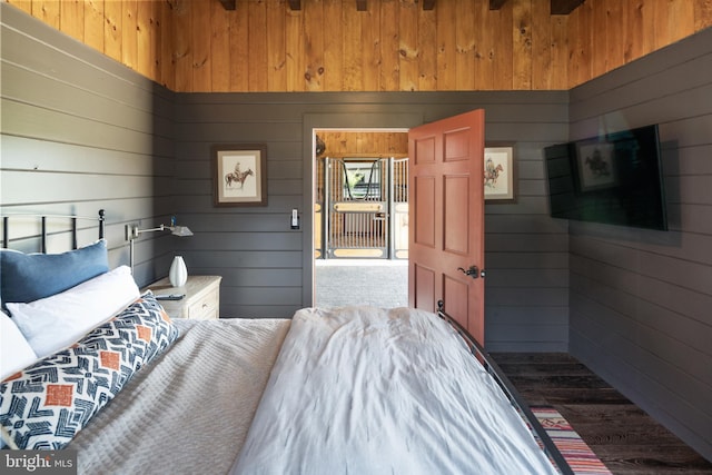 bedroom with wood walls and wood-type flooring