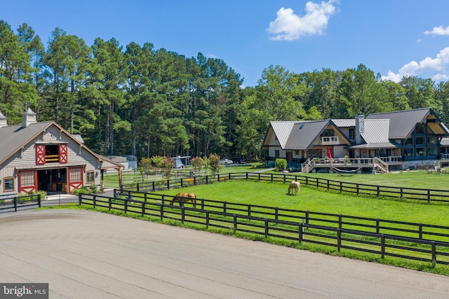 view of property's community with a rural view and a lawn