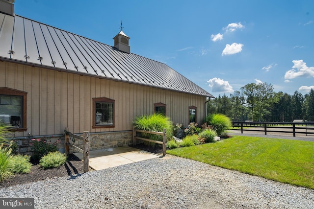 view of property exterior with a patio area and a lawn