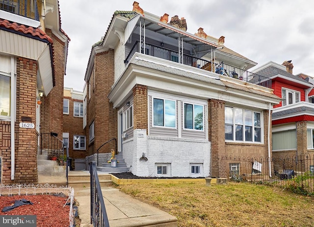 view of side of home with a balcony and a yard