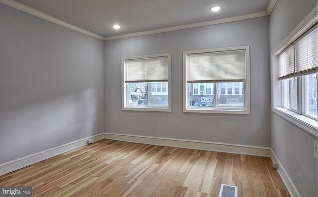 spare room featuring crown molding and light hardwood / wood-style flooring