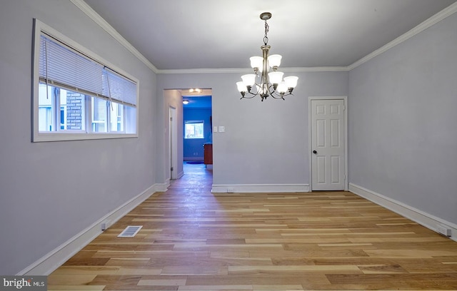 unfurnished dining area featuring ornamental molding, light wood-type flooring, and a notable chandelier