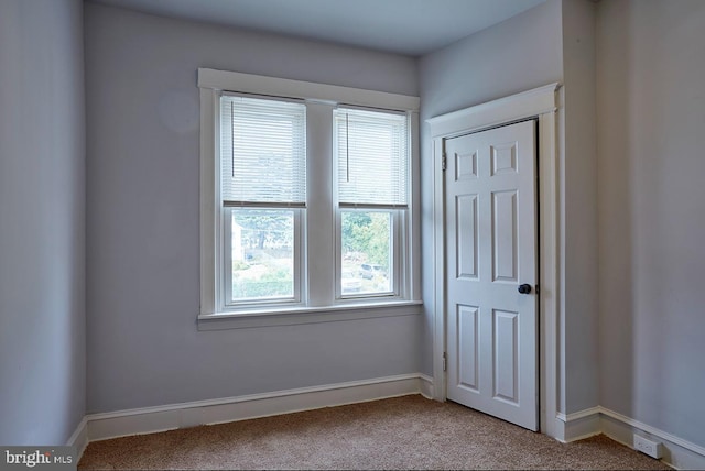 unfurnished room featuring light carpet