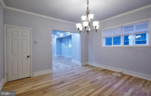 unfurnished dining area with a notable chandelier, light wood-type flooring, and ornamental molding