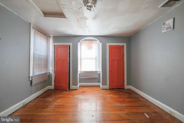 unfurnished room featuring a healthy amount of sunlight and hardwood / wood-style floors