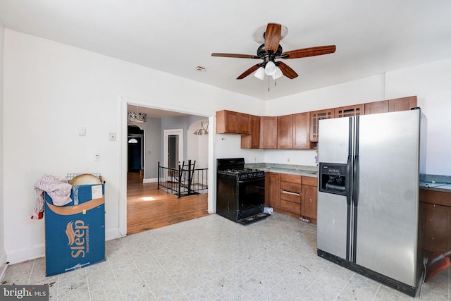 kitchen with gas stove, stainless steel fridge, light wood-type flooring, and ceiling fan