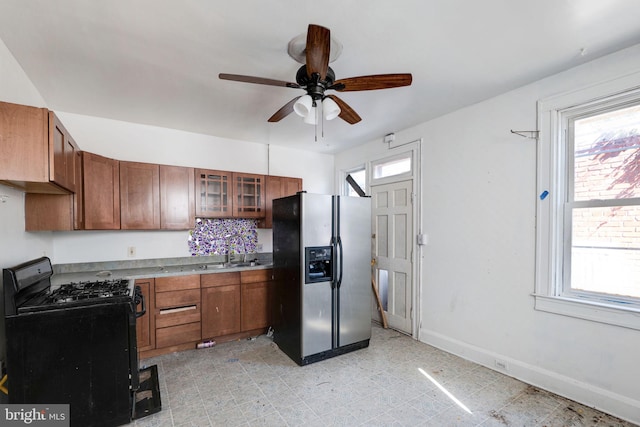 kitchen featuring stainless steel fridge, a healthy amount of sunlight, and black range