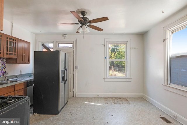 kitchen featuring ceiling fan, stainless steel appliances, and sink