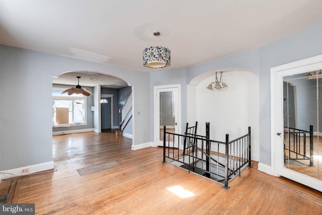 corridor with hardwood / wood-style flooring and a notable chandelier