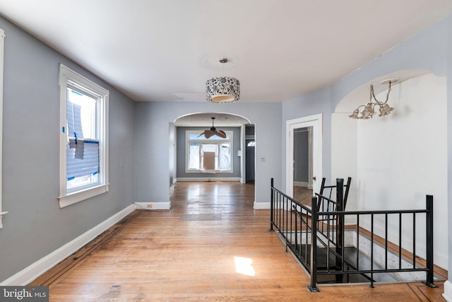 corridor with a chandelier and light wood-type flooring