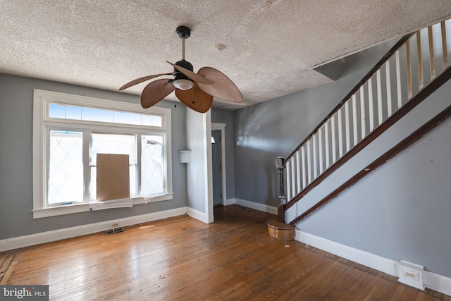 unfurnished living room with ceiling fan, hardwood / wood-style flooring, and a textured ceiling