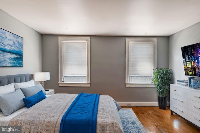 bedroom with wood-type flooring and multiple windows