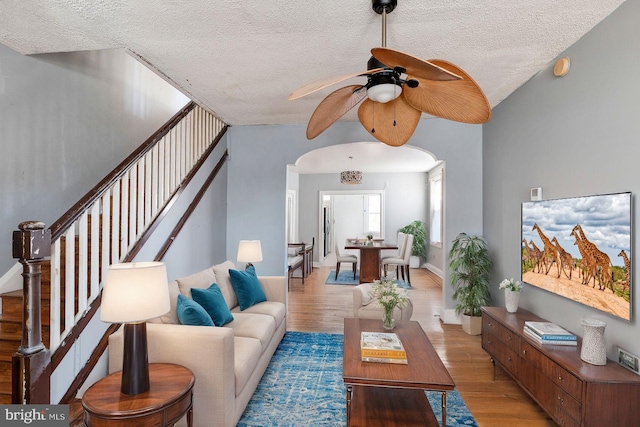 living room with light wood-type flooring and a textured ceiling