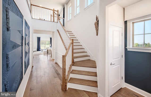 stairway with wood-type flooring and plenty of natural light