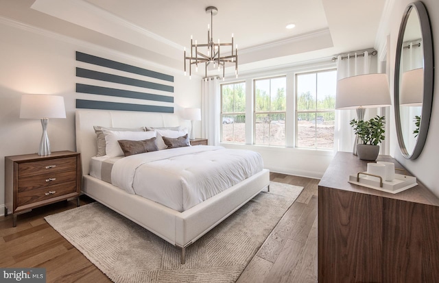 bedroom featuring dark wood-type flooring, ornamental molding, and an inviting chandelier