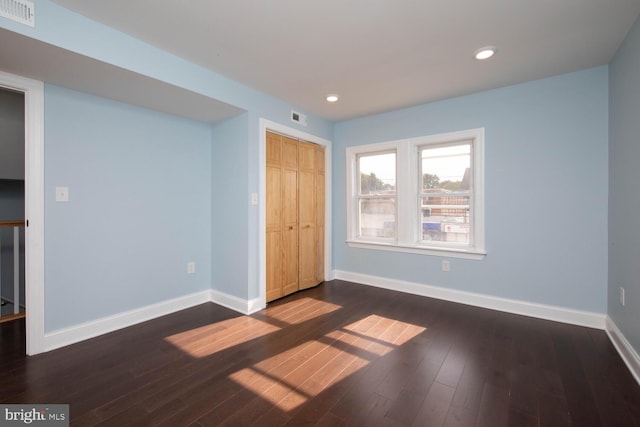 unfurnished bedroom featuring a closet and dark hardwood / wood-style flooring