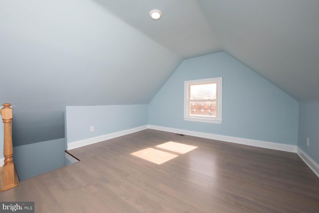 additional living space with lofted ceiling and dark hardwood / wood-style flooring