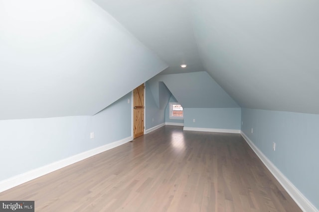 additional living space featuring hardwood / wood-style floors and vaulted ceiling