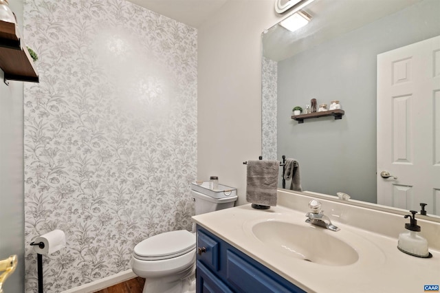 bathroom featuring vanity, toilet, and hardwood / wood-style flooring