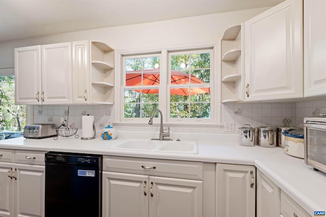 kitchen with decorative backsplash, black dishwasher, sink, and white cabinetry