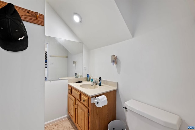 bathroom with vaulted ceiling, vanity, and toilet