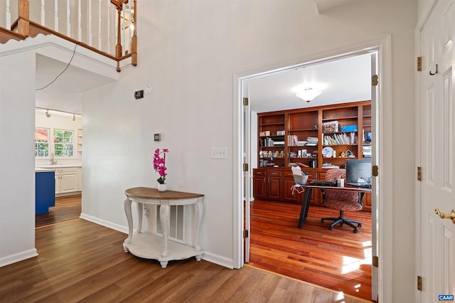 hall with hardwood / wood-style flooring and sink