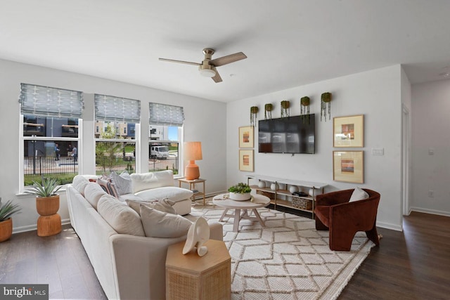 living area featuring ceiling fan, baseboards, and wood finished floors