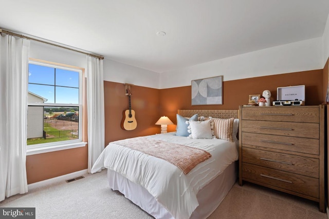 bedroom with visible vents, baseboards, and light carpet