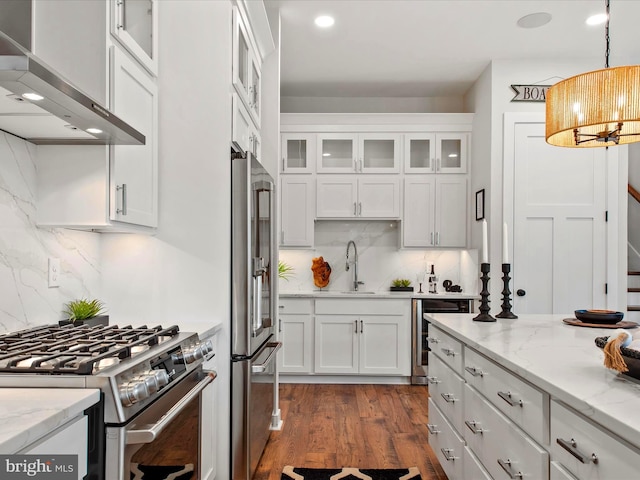 kitchen featuring stainless steel appliances, ventilation hood, white cabinets, and sink